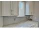 Close-up of kitchen features including white cabinets, granite countertops, and a gray subway tile backsplash at 17809 Pawleys Plantation Ln, Charlotte, NC 28278