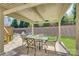 Covered patio with outdoor seating overlooking the manicured lawn and retaining wall at 17809 Pawleys Plantation Ln, Charlotte, NC 28278