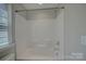 White shower-tub combination with new fixtures, offering a clean and modern bathing space at 17809 Pawleys Plantation Ln, Charlotte, NC 28278