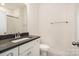 Bright bathroom featuring a sleek vanity with black countertop, modern fixtures, and minimalist design elements at 2021 Summey Ave, Charlotte, NC 28205