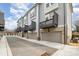 Modern townhomes featuring garages, gray siding, and small dark balconies on each unit at 2021 Summey Ave, Charlotte, NC 28205