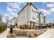 Beautiful townhome exterior featuring mixed siding, brick, professional landscaping, wrought iron fencing and a stone retaining wall at 2021 Summey Ave, Charlotte, NC 28205