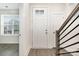 Bright foyer with wood flooring, white door with glass insert and modern staircase with black iron pickets at 2021 Summey Ave, Charlotte, NC 28205