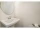 Small powder room with white pedestal sink and round mirror at 2021 Summey Ave, Charlotte, NC 28205