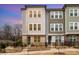 Modern townhouses featuring gray siding, brick accents, black iron fencing, and manicured landscaping at 2021 Summey Ave, Charlotte, NC 28205