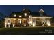 Exterior nighttime shot of a beautiful home with manicured lawn and landscape lighting at 2036 Rocky Stream Rd, York, SC 29745