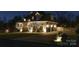 Exterior nighttime shot of a beautiful home with stone accents, side-entry garage, and manicured landscaping at 2036 Rocky Stream Rd, York, SC 29745