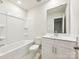 Clean bathroom featuring white cabinets, a well-lit mirror, and a bathtub with tiled walls, ideal for relaxation at 2080 Old Rivers Rd, Concord, NC 28027