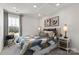 Cozy bedroom features patterned bedding, neutral walls, bedside tables and large window at 2080 Old Rivers Rd, Concord, NC 28027