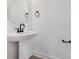 Minimalist bathroom featuring modern pedestal sink and sleek black fixtures at 211 E Rice St, Landis, NC 28088