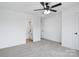 Bright bedroom showcasing a ceiling fan, neutral carpet, and an adjacent bathroom with a tub and shower at 211 E Rice St, Landis, NC 28088