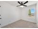 A bright bedroom features a window with outdoor views and neutral carpet at 211 E Rice St, Landis, NC 28088