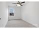 Bright bedroom featuring neutral carpet, a ceiling fan with lights, and a window that offers an exterior view at 211 E Rice St, Landis, NC 28088