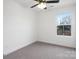 Bright bedroom features soft carpet, a ceiling fan, and a large window at 211 E Rice St, Landis, NC 28088