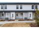 Charming townhouse featuring white siding, dark trim, and well-maintained landscaping, creating a welcoming curb appeal at 211 E Rice St, Landis, NC 28088