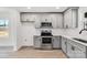 Well-lit kitchen featuring stainless steel appliances and stylish gray cabinetry at 211 E Rice St, Landis, NC 28088