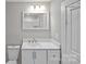 Bathroom featuring white vanity, sink, toilet, and a large mirror above the sink at 220 W Bell St, Statesville, NC 28677