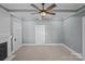 Bedroom featuring carpet floors, a ceiling fan, a fireplace, and multiple doors at 220 W Bell St, Statesville, NC 28677