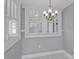 Well-lit dining room featuring chandelier, gray walls, white trim and large windows at 220 W Bell St, Statesville, NC 28677