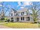 Charming two-story home featuring a wrap-around porch, a metal roof, and a well-manicured lawn at 220 W Bell St, Statesville, NC 28677