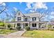 Charming two-story home featuring a wrap-around porch, a metal roof, and a well-manicured lawn at 220 W Bell St, Statesville, NC 28677