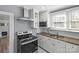 Kitchen features white cabinets, modern stainless steel range hood at 220 W Bell St, Statesville, NC 28677