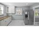 Well-lit kitchen featuring stainless steel refrigerator, white cabinets and marble tile floors at 220 W Bell St, Statesville, NC 28677