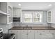 Kitchen featuring white cabinets, tiled backsplash, and a stainless steel range hood at 220 W Bell St, Statesville, NC 28677