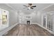 Living room featuring hardwood floors, a ceiling fan, fireplace, and glass french doors at 220 W Bell St, Statesville, NC 28677