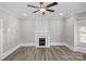 Bright living room with updated floors, ceiling fan, and a fireplace with mosaic tile accent at 220 W Bell St, Statesville, NC 28677