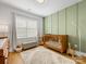 Cozy Bedroom featuring a wooden crib, green accent wall, and soft, neutral-toned decor at 2626 Palm Ave, Charlotte, NC 28205