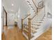 Bright entryway featuring hardwood floors, a staircase with wooden railings, and white trim at 2626 Palm Ave, Charlotte, NC 28205