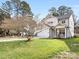 Beautifully landscaped yard surrounds a white two-story home with wooden accents and a welcoming front porch at 2626 Palm Ave, Charlotte, NC 28205