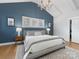 Serene main bedroom featuring a plush bed, blue accent wall, and large windows at 2626 Palm Ave, Charlotte, NC 28205