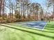 Full tennis court surrounded by trees, perfect for outdoor recreation and sports at 2626 Palm Ave, Charlotte, NC 28205