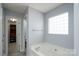 Bathroom featuring a jetted tub, glass block window, and access to a walk-in closet at 280 Bonaventure Dr, Salisbury, NC 28147