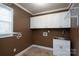 Functional laundry room with white cabinetry, sink and tile flooring at 280 Bonaventure Dr, Salisbury, NC 28147