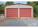 Detached garage with red roll-up doors, offering convenient storage and parking at 2909 Glendale Ave, Kannapolis, NC 28081