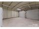 Clean garage interior with roll-up door, lighting, and smooth concrete floor at 2909 Glendale Ave, Kannapolis, NC 28081