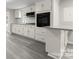 Modern white kitchen featuring updated appliances, stone countertops, and gray laminate flooring at 2909 Glendale Ave, Kannapolis, NC 28081