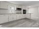 Modern white kitchen featuring updated appliances, stone countertops, and gray laminate flooring at 2909 Glendale Ave, Kannapolis, NC 28081