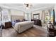 Main bedroom featuring hardwood floors, large windows, a ceiling fan, and a tray ceiling at 2929 Shumard Dr, Gastonia, NC 28054