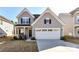 Charming two-story home with gray siding, black shutters, and a two-car garage at 3180 Streamside Dr, Davidson, NC 28036