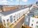 Aerial view of modern townhome community with gray siding and orange accents, city skyline in distance at 3621 Vallette Ct, Charlotte, NC 28203