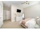 Bright bedroom features a ceiling fan, television and a dresser with mirror, complemented by neutral tones at 3621 Vallette Ct, Charlotte, NC 28203