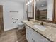 Bathroom featuring double granite sink, bronze fixtures, and wood-look tile at 3792 Rolling View Ln, Maiden, NC 28650