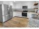 Modern kitchen featuring stainless appliances, white cabinets, granite countertops, and wood-look flooring at 3792 Rolling View Ln, Maiden, NC 28650