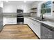 Modern kitchen featuring white cabinets, granite countertops, stainless steel appliances, and wood-look flooring at 3792 Rolling View Ln, Maiden, NC 28650