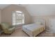 Attic bedroom with sloped ceilings, a patterned bedspread, and natural light from a window at 409 Conaway Ct, Waxhaw, NC 28173