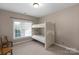 Neutral bedroom showcasing a wooden bunk bed with window view and carpeted flooring at 409 Conaway Ct, Waxhaw, NC 28173